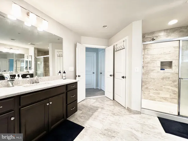 a bathroom with a shower sink and mirror