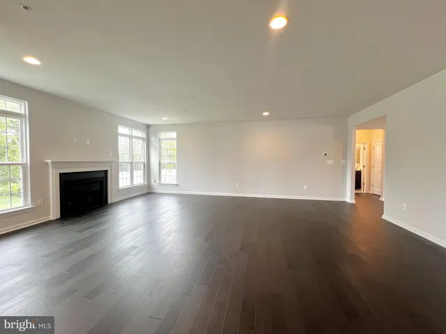 an empty room with wooden floor and fireplace