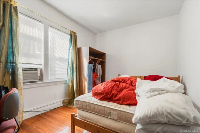 a living room with a bed and dresser next to a window