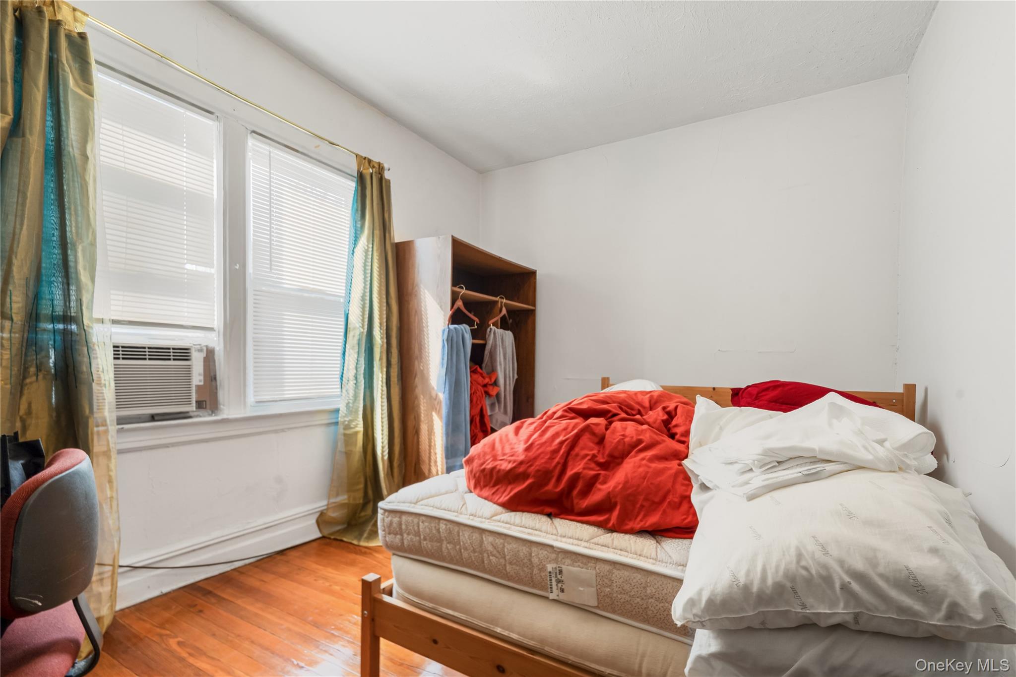 104-37 125th Street Queens, NY 11419 - Photo 13 of 24 a living room with a bed and dresser next to a window