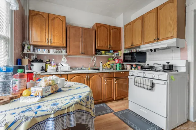 a kitchen with stainless steel appliances granite countertop a stove a sink dishwasher and cabinets with wooden floor