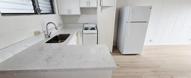 a kitchen with stainless steel appliances a sink a stove and a refrigerator with wooden floor