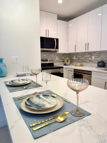 a large kitchen with kitchen island a sink stainless steel appliances and cabinets