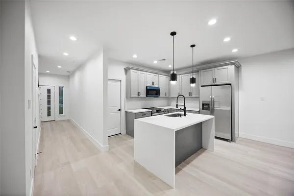a kitchen with a sink stove and refrigerator