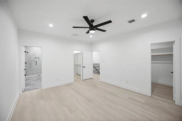 an empty room with closet and windows