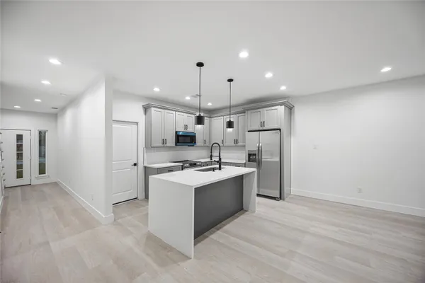 a kitchen with kitchen island a sink stainless steel appliances and cabinets
