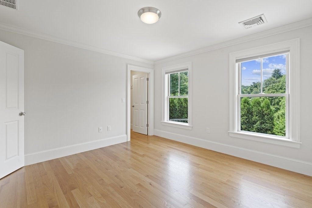 279 Emerson Road Lexington, MA 02420 - Photo 21 of 29 an empty room with wooden floor and windows
