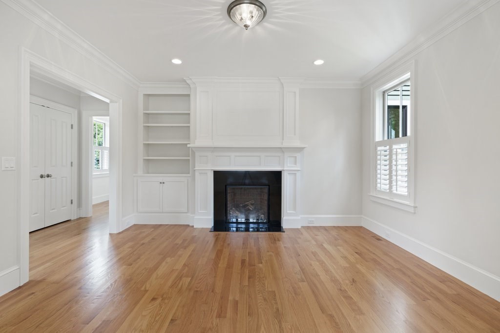 279 Emerson Road Lexington, MA 02420 - Photo 4 of 29 a view of an empty room with wooden floor fireplace and a window