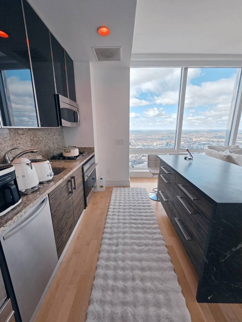 401 North Wabash Avenue, Unit 79C Chicago, IL 60611 - Photo 7 of 38 a kitchen with a sink stove and cabinets