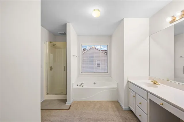a bathroom with a tub sink and mirror