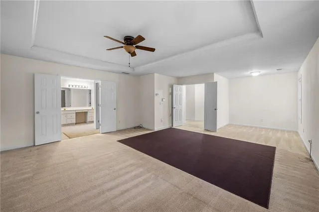 a view of an empty room with a window and a kitchen