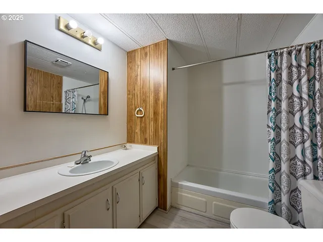 a bathroom with a sink a mirror a shower and a bathtub