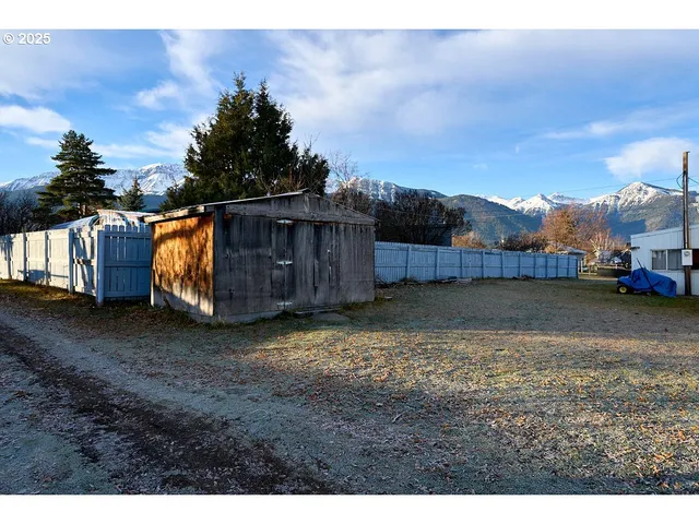 a view of a backyard with large trees