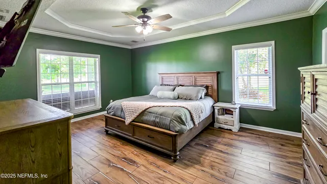 a bed sitting in a spacious bedroom next to a window