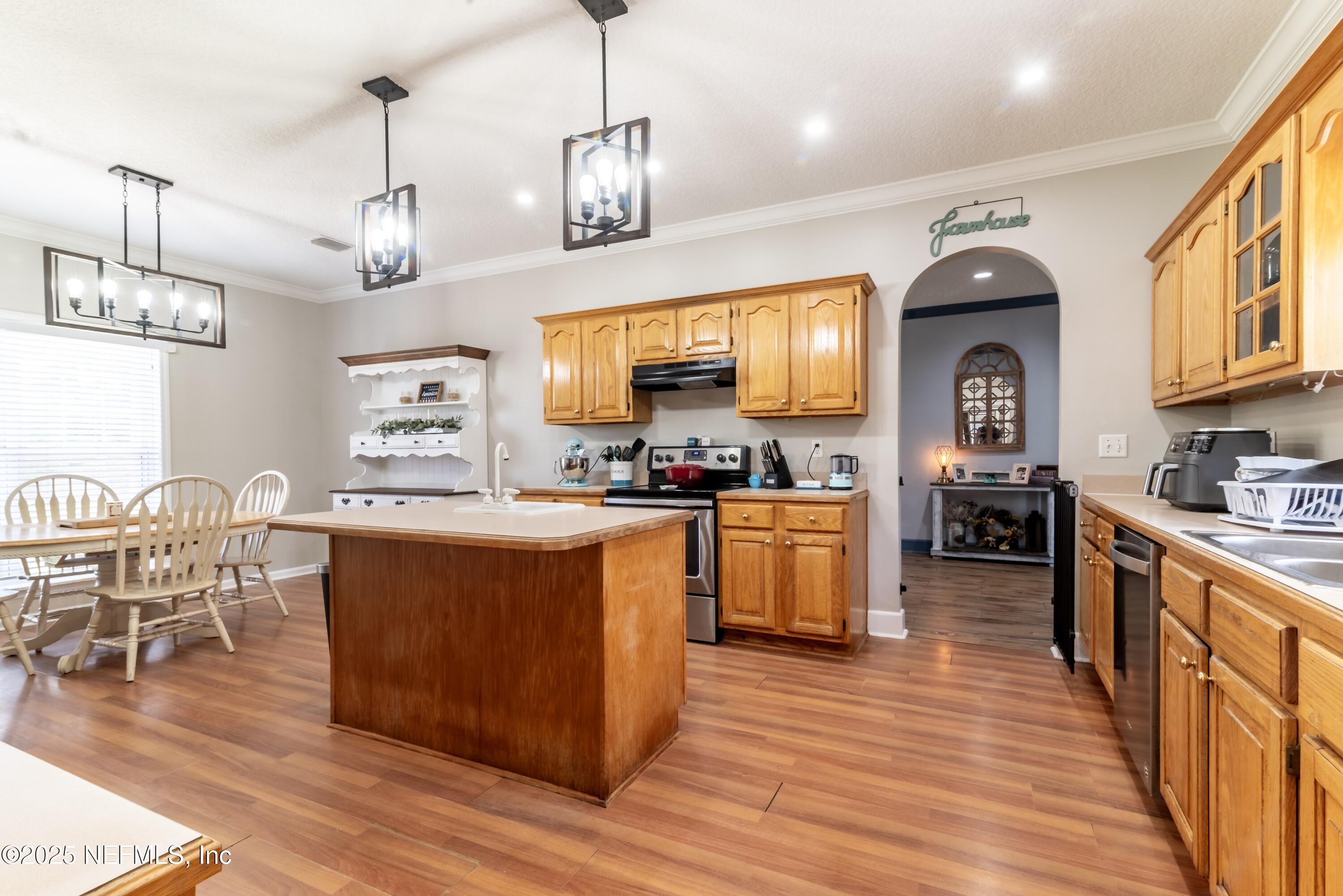 13561 Arnold Rhoden Road Glen St. Mary, FL 32040 - Photo 9 of 38 a large kitchen with stainless steel appliances granite countertop a stove oven a dining table and chairs with wooden floor