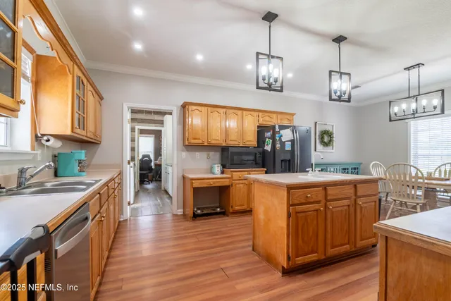 a kitchen with stainless steel appliances granite countertop wooden floors and white cabinets