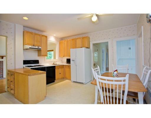 43 Colburn Road Wellesley, MA 02481 - Photo 4 of 14 a kitchen with kitchen island a refrigerator a stove a sink dishwasher and a dining table with wooden floor