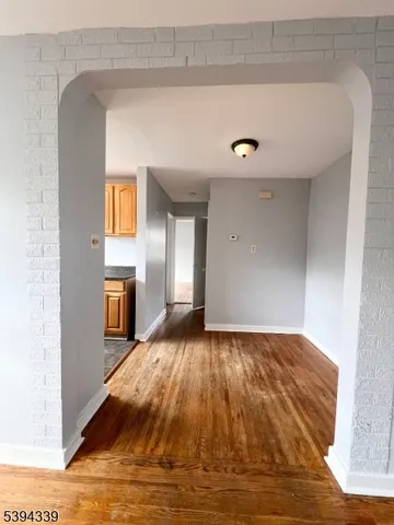a view of a livingroom with wooden floor and staircase