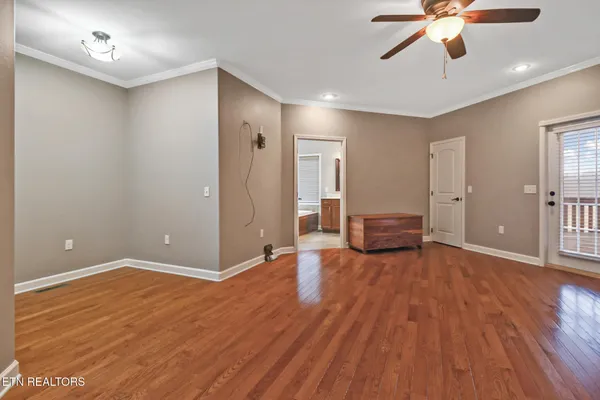 a view of an empty room with window and wooden floor