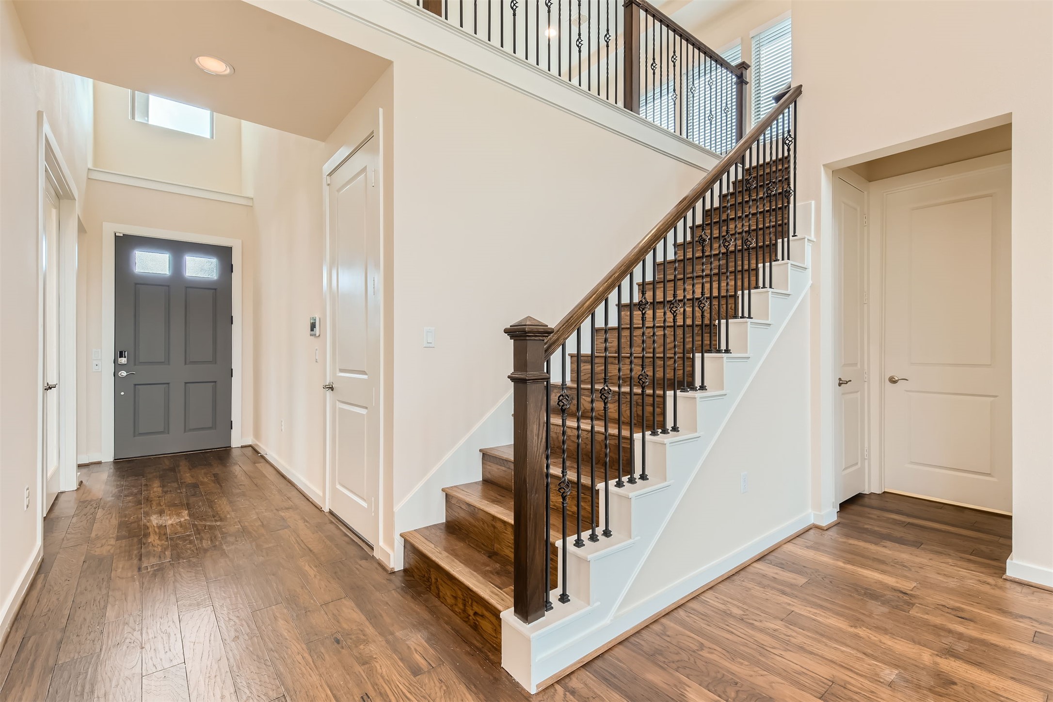 8313 Spire View Austin, TX 78744 - Photo 5 of 33 A grand entrance with rich hardwood floors welcomes you, leading to an elegant staircase with wrought iron balusters.