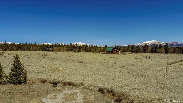 a view of a dry yard with mountains in the background