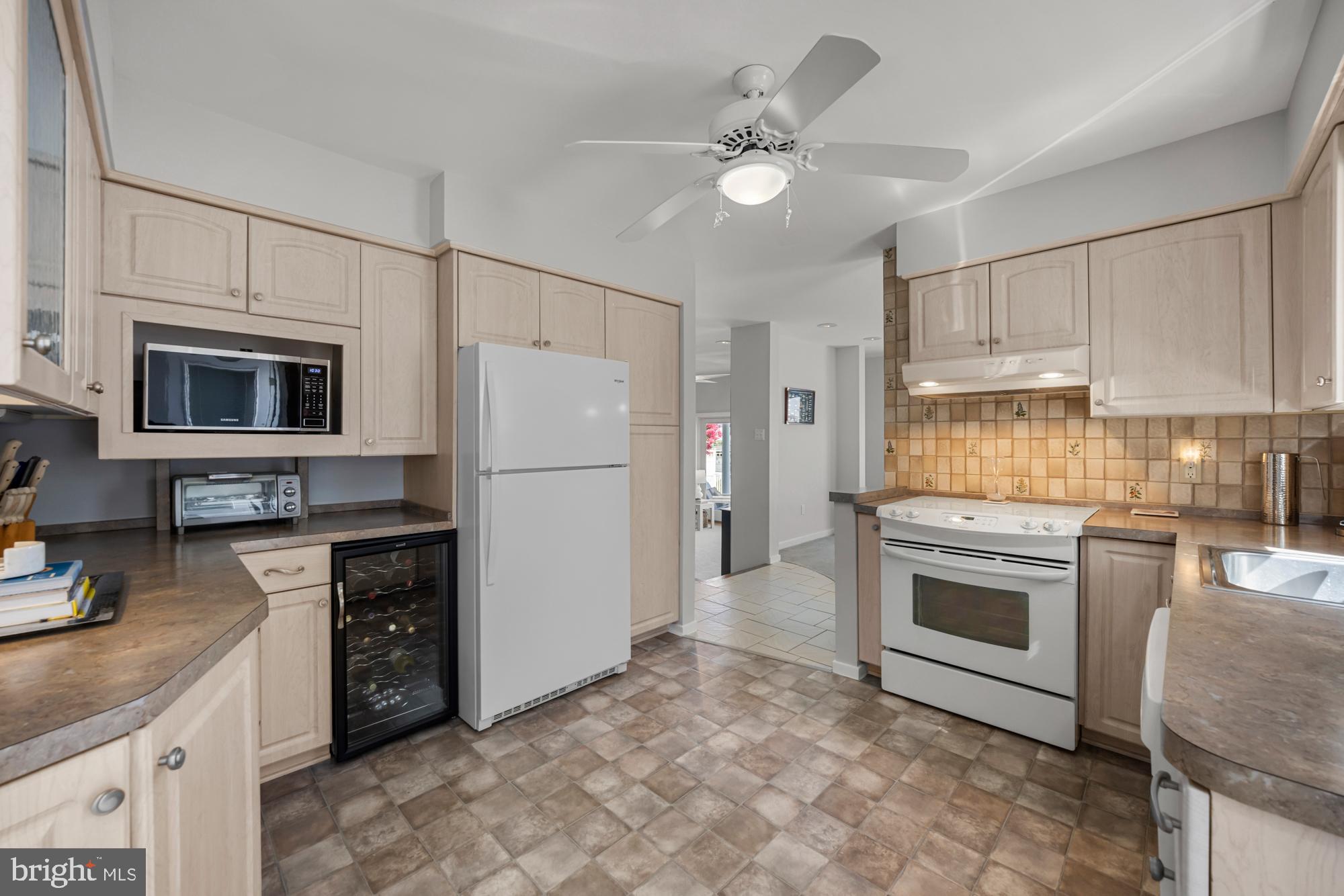 87 Lagoon Boulevard Brigantine, NJ 08203 - Photo 21 of 66 a kitchen with stainless steel appliances granite countertop a stove top oven a sink and a refrigerator