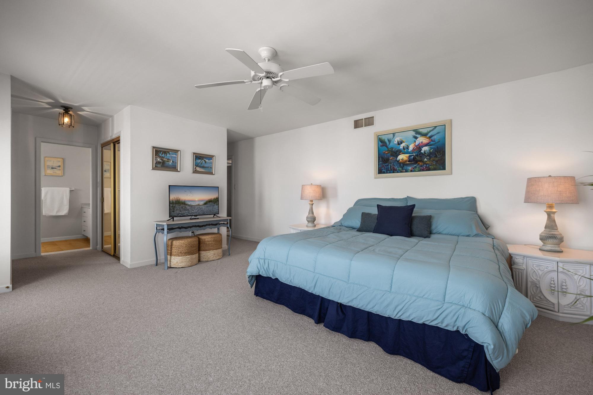 87 Lagoon Boulevard Brigantine, NJ 08203 - Photo 26 of 66 a spacious bedroom with a bed and a chandelier