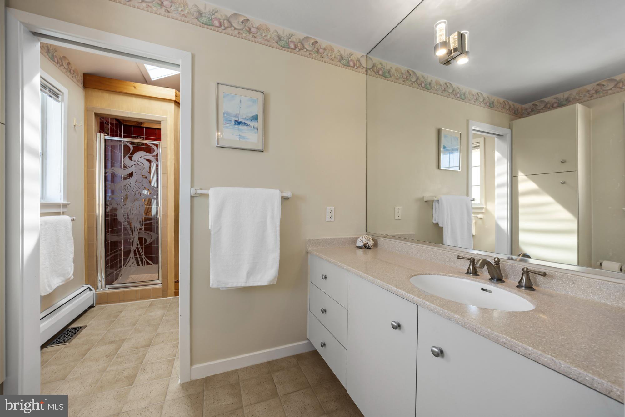 87 Lagoon Boulevard Brigantine, NJ 08203 - Photo 30 of 66 a spacious bathroom with a double vanity sink a mirror and a shower