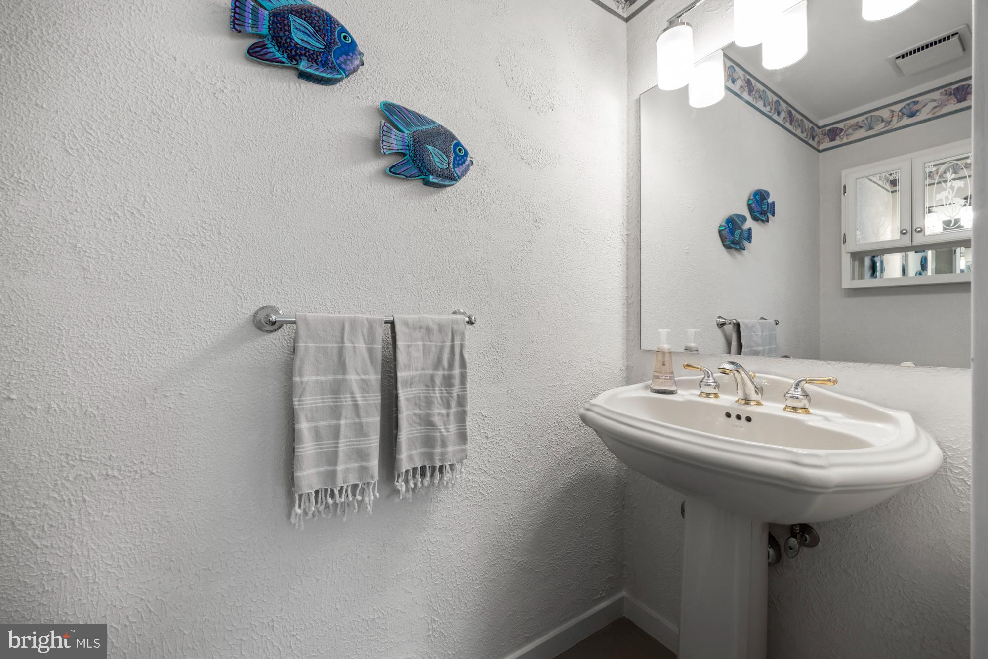 87 Lagoon Boulevard Brigantine, NJ 08203 - Photo 35 of 66 a bathroom with a sink a mirror and wooden floor