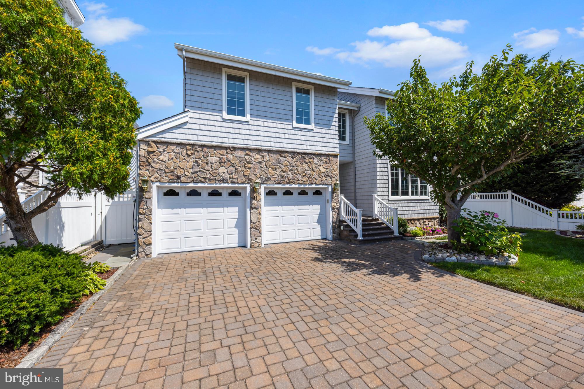 87 Lagoon Boulevard Brigantine, NJ 08203 - Photo 4 of 66 a front view of a house with a yard and garage