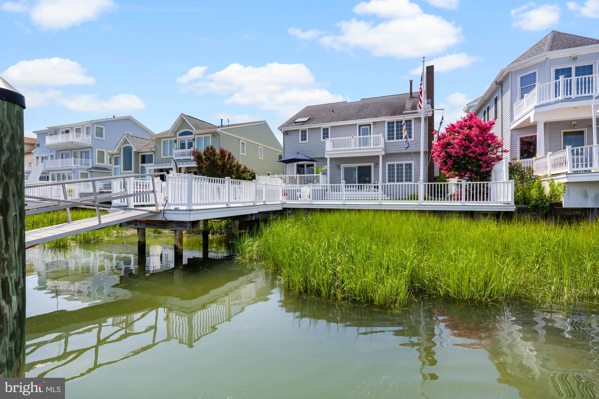 87 Lagoon Boulevard Brigantine, NJ 08203 - Photo 58 of 66 a view of a lake with a building next to a yard