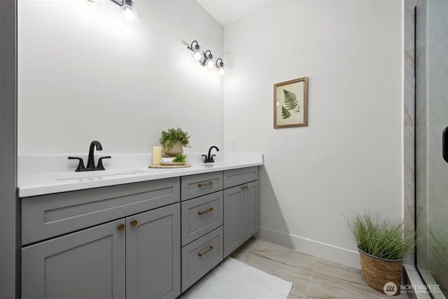 a bathroom with a sink a mirror and potted plant