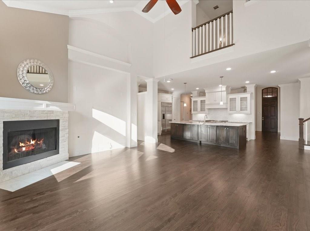 4026 North Cresthaven Road Dallas, TX 75209 - Photo 8 of 22 a view of a kitchen and an empty room with wooden floor a fireplace