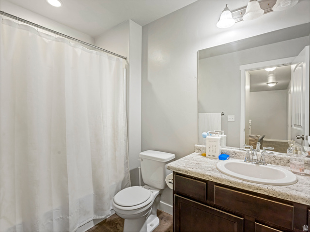 12214 Sunpark Lane Draper, UT 84020 - Photo 15 of 24 Full bathroom featuring vanity, dark wood-style flooring, and shower / tub combo with curtain