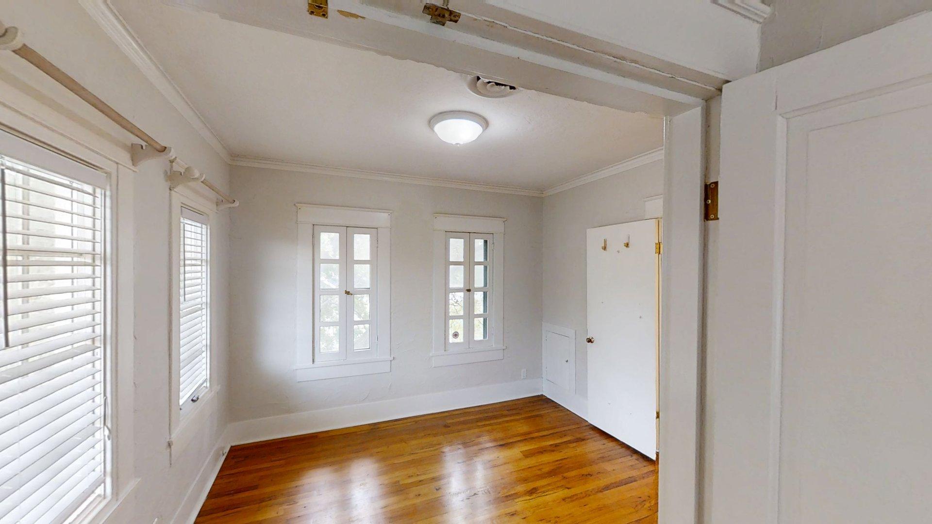 219 F Street Southwest Ardmore, OK 73401 - Photo 26 of 58 Hardwood-finish flooring, multiple windows with blinds, crown molding, and a flush mount ceiling light