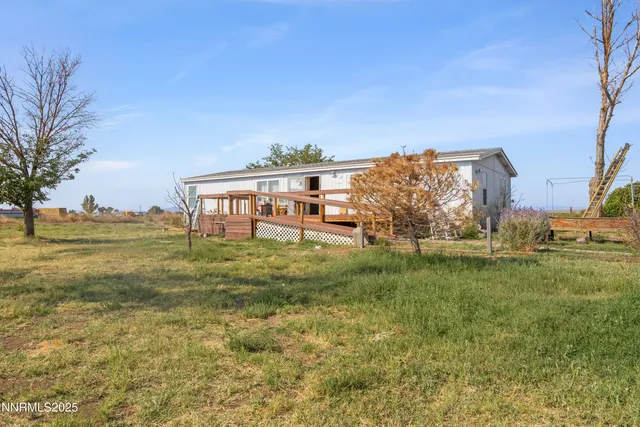 a view of a big house with a big yard and large trees