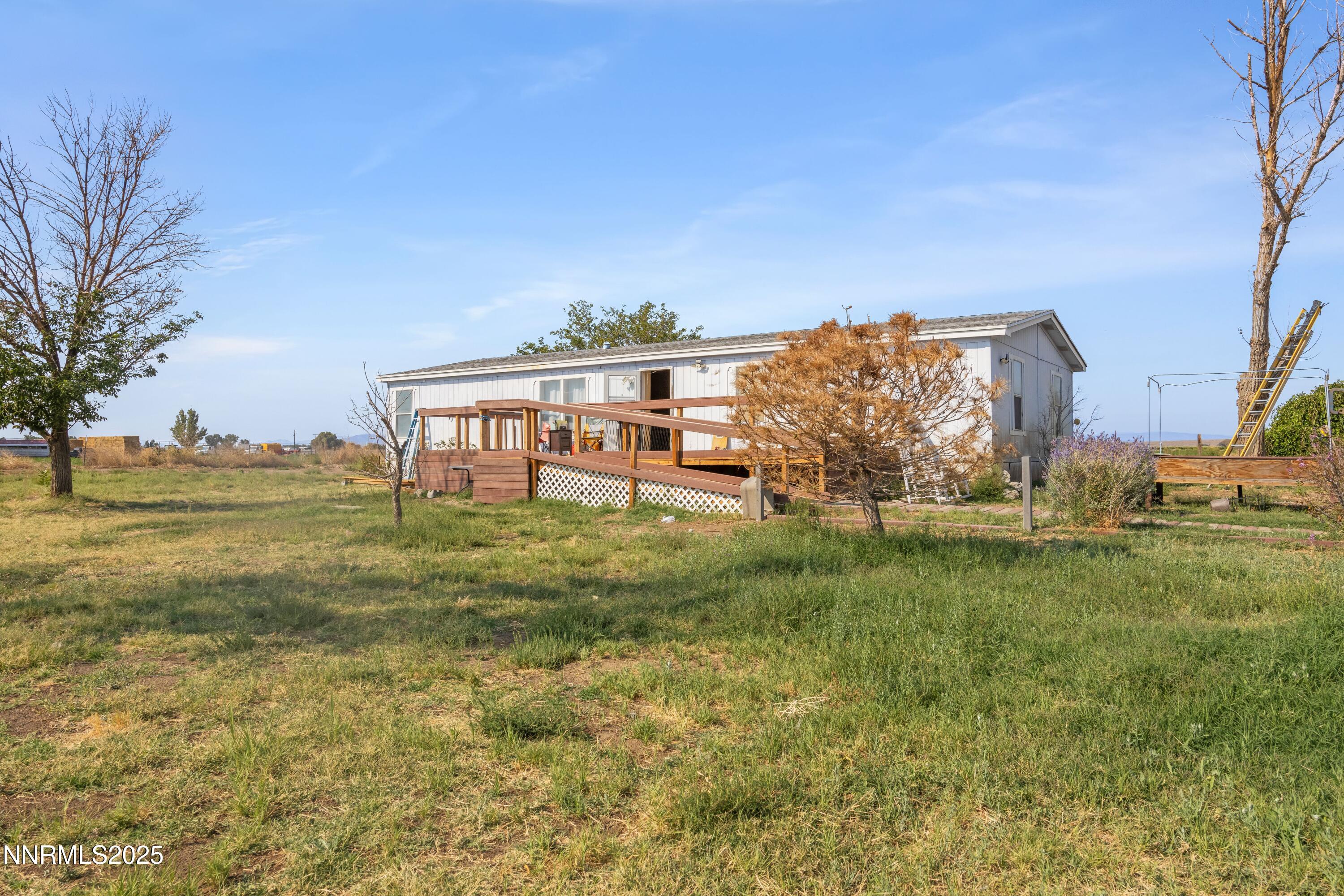 a view of a big house with a big yard and large trees