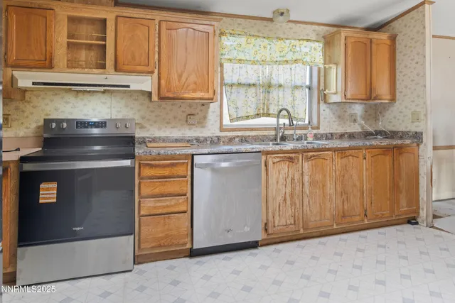 a kitchen with stainless steel appliances granite countertop a stove a sink and a microwave
