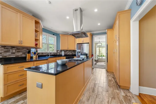 a kitchen with stainless steel appliances granite countertop a sink a stove and a refrigerator