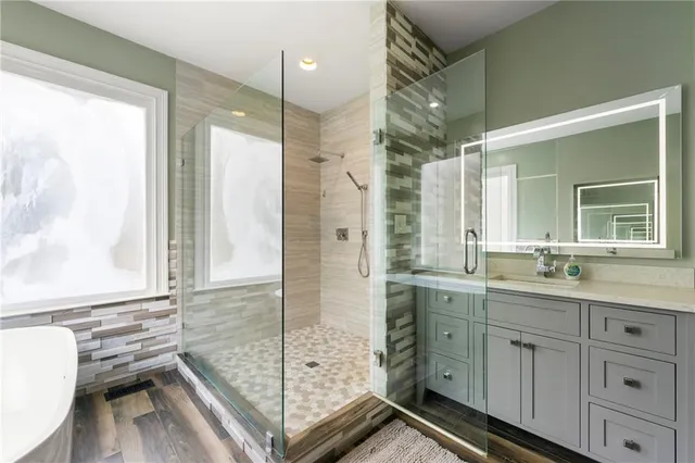 a spacious bathroom with double vanity and a shower