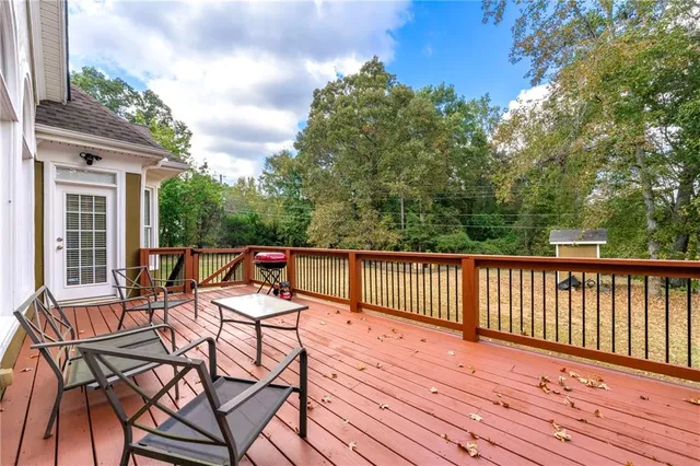 a roof deck with table and chairs and wooden floor
