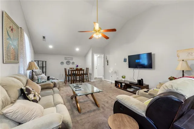 a living room with furniture a ceiling fan and a rug
