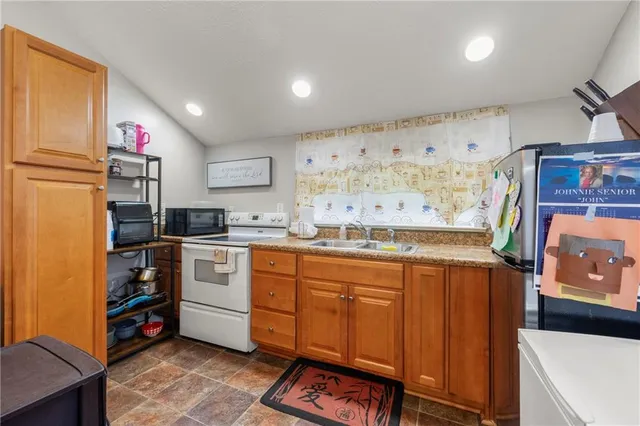 a kitchen with stainless steel appliances granite countertop a refrigerator and a stove top oven