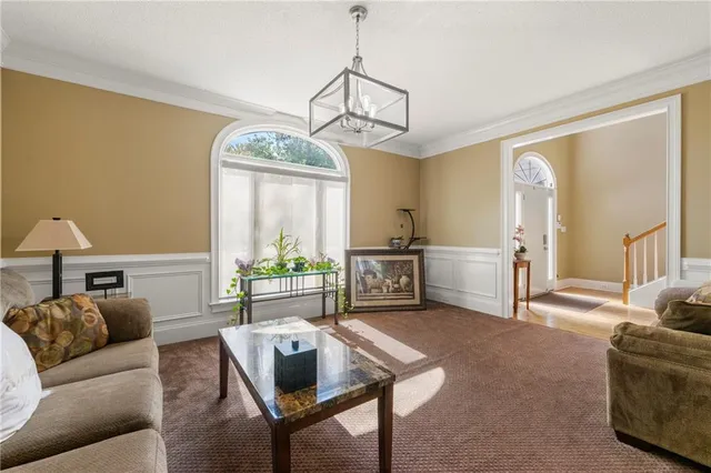 a living room with furniture a window and a chandelier