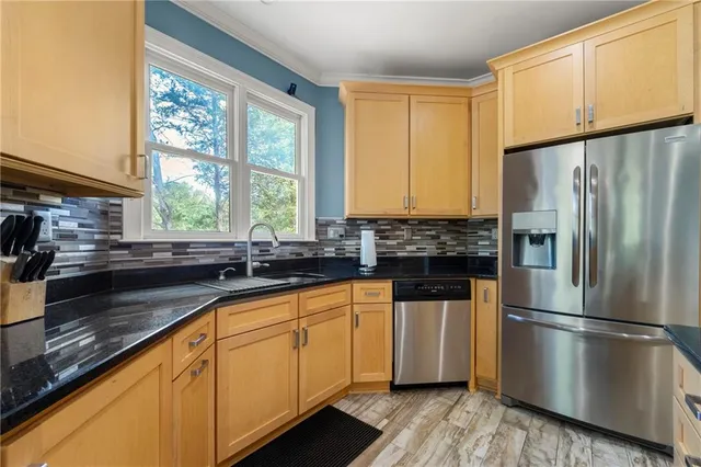 a kitchen with stainless steel appliances a refrigerator sink and cabinets