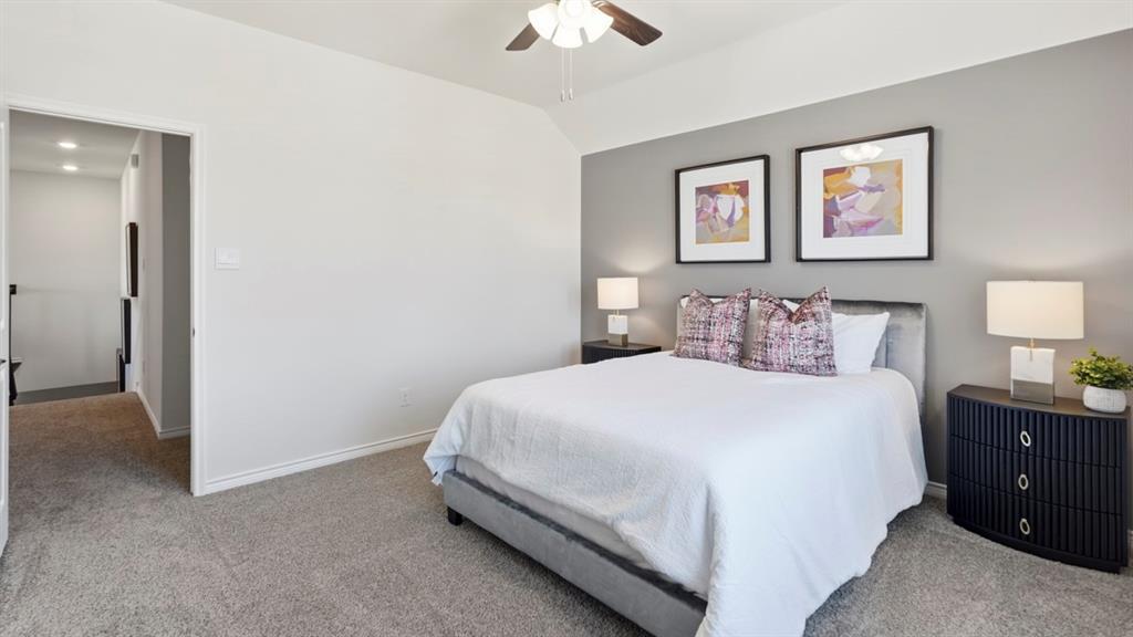 4197 Waldron Trail Forney, TX 75126 - Photo 20 of 25 Carpeted bedroom featuring a tray ceiling with a ceiling fan, a contrasting accent wall, and a doorway opening to a hallway with recessed lighting
