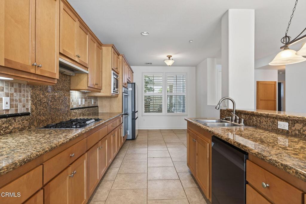 1423 Windshore Way Oxnard, CA 93035 - Photo 14 of 77 a large kitchen with granite countertop a sink and a stove
