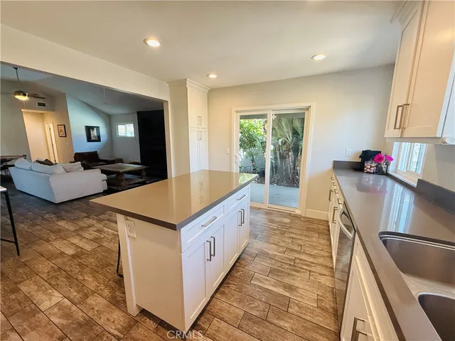 a large kitchen with stainless steel appliances a stove a sink dishwasher and cabinets with wooden floor