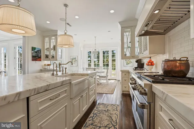 a kitchen with stainless steel appliances granite countertop a sink a stove and a wooden floors