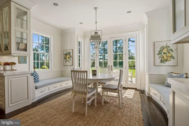 a dining room with furniture a chandelier and wooden floor